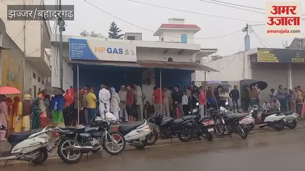 People queuing for gas cylinders amidst the rain in Jhajjar.