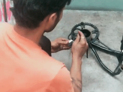 अपने हाथ से बनाए गए जुगाड़ चूल्हे को जलाता युवक।